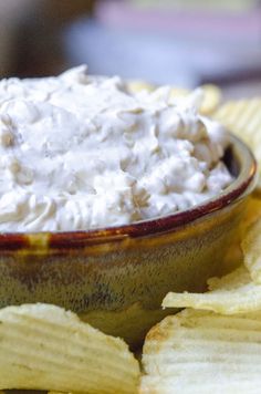 a bowl filled with cream cheese surrounded by chips