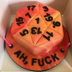 a cake that has been decorated with numbers and dices on the top it is in a box