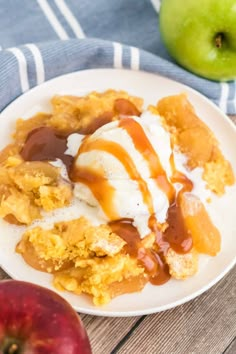 an apple cobbler with ice cream and caramel sauce on a plate next to an apple