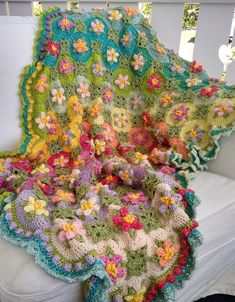 a crocheted blanket is sitting on a couch