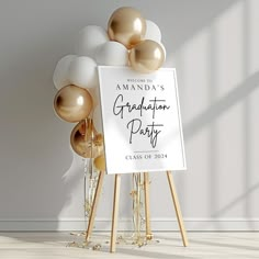 a graduation party sign with gold and white balloons in front of it on an easel