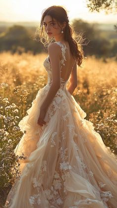 a woman standing in a field wearing a dress with flowers on the skirt and back