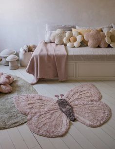 a room with teddy bears and stuffed animals on the floor in front of a bed