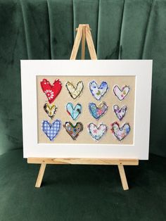 a wooden easel holding an art work with hearts on the front and back of it