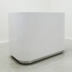 a large white box sitting on top of a cement floor next to a wall in a room