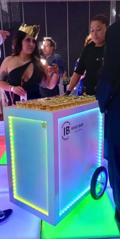 a man and woman standing next to a table with food on it