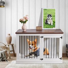 a dog in a cage with a picture frame on the table next to it and flowers