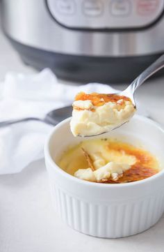 a spoon full of food sitting next to an instant pot