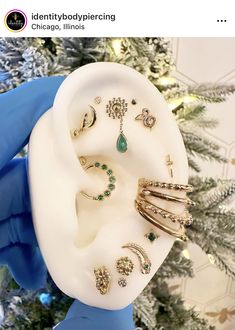 an earring holder with several different jewelry pieces on it's side, in front of a christmas tree