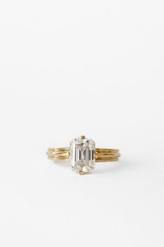 an oval cut diamond engagement ring in yellow gold with two bands on the band, set against