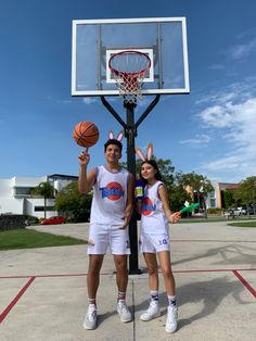 two people standing in front of a basketball hoop