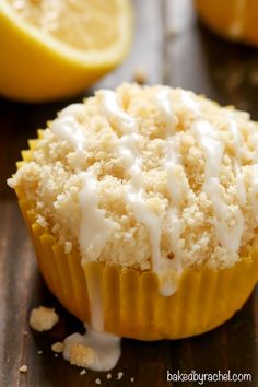 a close up of a muffin on a wooden table with lemons in the background