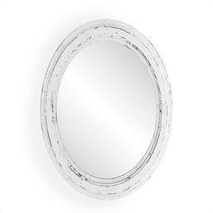 a white round mirror sitting on top of a wall