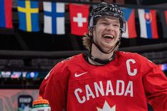 a man in a red jersey is smiling at the camera