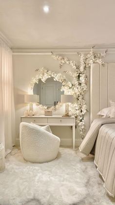 a bedroom decorated in white with a round mirror