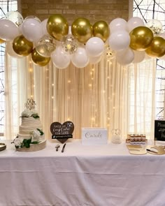 a table topped with a cake and balloons