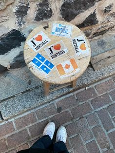 a person standing next to a wooden table with stickers on it's side