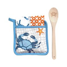 a wooden spoon sitting next to a blue and white bib with crab on it