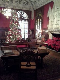 a christmas tree is lit up in the middle of a room with chairs and tables