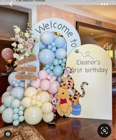 winnie the pooh birthday party decoration with balloons and welcome sign for your child's first birthday