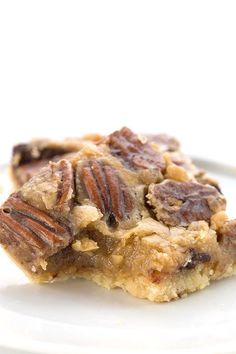 a piece of pecan bar sitting on top of a white plate