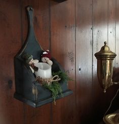 a candle is sitting on a shelf next to a lamp and other items in a room with wood paneling