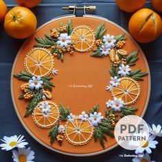 oranges and daisies are arranged in an embroidery pattern