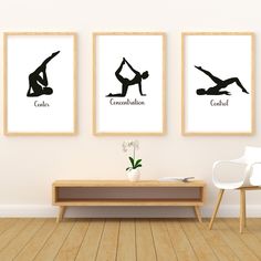 three framed yoga prints on the wall above a coffee table