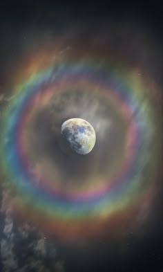 an image of a rainbow ring in the sky with clouds and planets around it, as seen from space