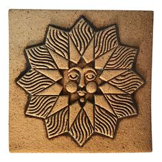 an intricately designed sunflower is shown on the side of a stone wall or floor