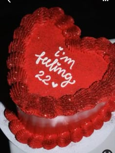 a red heart shaped cake with the words mr and mrs written on it's side