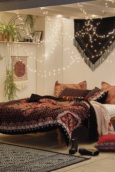 a bed room with a neatly made bed and string lights hanging from the wall above it