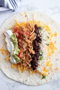 a tortilla topped with black beans, cheese and guacamole