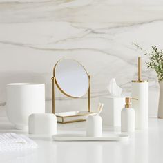 white bathroom accessories with gold accents and marble background