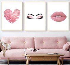 two paintings on the wall above a pink couch and coffee table in a living room