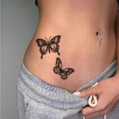 a woman's stomach with two butterflies on it and the bottom part of her belly