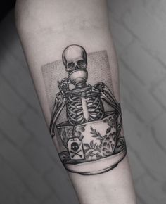 a skeleton sitting in a flower pot on the arm