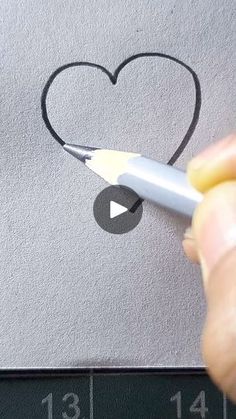 someone is drawing a heart with a pencil