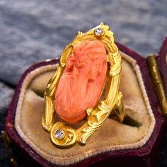 This antique Art Nouveau ring has a haut relief cameo carved from a long piece of coral. The cameo is set with four prongs into a swirl and botanical motif setting, accented on each end by a bezel-set single cut diamond. The ring is crafted in 10k yellow gold with a high karat wash, and is currently a size 4. Antique Engagement Rings Sapphire, Estate Jewelry Rings, Art Nouveau Ring, Wedding Ring Diamond Band, Cameo Ring, Antique Engagement Rings, European Cut Diamonds, Sapphire Engagement, Engagement Rings Sapphire