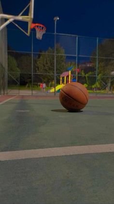 a basketball sitting on top of a basketball court next to a basket ball in the air