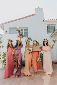 the bridesmaids are holding their bouquets and posing in front of a house