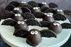 there are chocolate covered cookies with eyes and wings on the cake platter for halloween