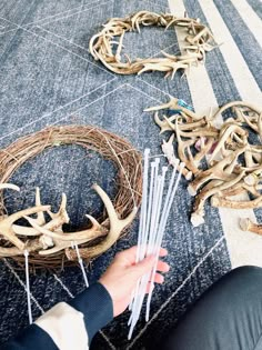 a person is sitting on the floor next to some antlers and other items that have been placed in front of them