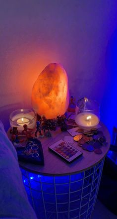 a table with candles and other items on it next to a bed in a room