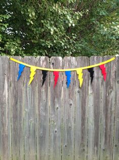 a wooden fence with colorful flags hanging from it