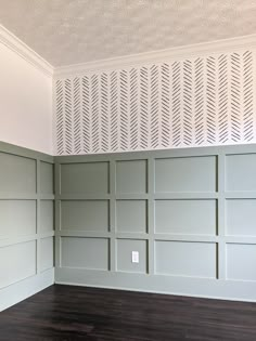 empty room with wood floor and white wall paneling on the walls in front of it