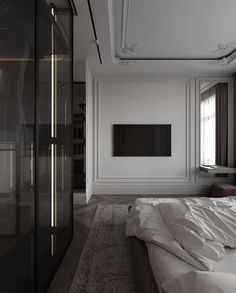 an empty bedroom with a large white bed and black wardrobes in the corner next to it