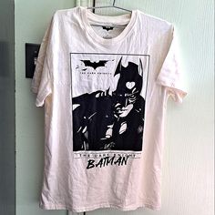 a batman t - shirt hanging on a door with an image of the same character