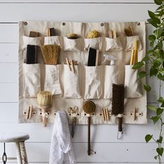 a wall hanging on the side of a white wall with lots of brushes and combs