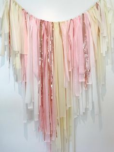 a pink, beige and white streamer with sequins hanging from the ceiling